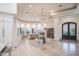 Bright and airy living room with elegant chandelier, marble floors, and grand fireplace at 35530 N Canyon Crossings Dr, Cave Creek, AZ 85331