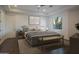 Cozy main bedroom with neutral tones, tray ceiling, bench, and natural light from a picture window at 35530 N Canyon Crossings Dr, Carefree, AZ 85377