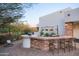 Elegant outdoor bar with stone accents, seating, and a serene desert landscape view at 35530 N Canyon Crossings Dr, Cave Creek, AZ 85331