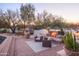 Charming outdoor living space featuring a stone fireplace and comfortable seating in a landscaped setting at 35530 N Canyon Crossings Dr, Cave Creek, AZ 85331