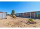 The backyard features a shed, desert landscaping, and brick accents surrounding a small decorative tree at 417 W Sunset Dr, Mammoth, AZ 85618