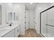 Modern bathroom features double sinks, Quartz countertops, and a glass shower with wood-look floors at 4513 W 95Th Dr, Tolleson, AZ 85353