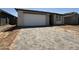 Charming single-story home with a brick driveway and a white garage door, offering a welcoming curb appeal at 4513 W 95Th Dr, Tolleson, AZ 85353