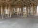 Framing of a spacious, partially constructed interior featuring wall studs, concrete flooring, and visible utilities at 4513 W 95Th Dr, Tolleson, AZ 85353