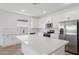 Modern kitchen featuring a large island, stainless steel appliances, and sleek white cabinetry at 4513 W 95Th Dr, Tolleson, AZ 85353