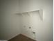 Compact laundry room with shelving, washer and dryer hookups for convenience at 4513 W 95Th Dr, Tolleson, AZ 85353