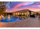 Backyard featuring a pool, fire pit, lounge chairs, and covered patio at sunset at 4675 S Bandit Rd, Gilbert, AZ 85297