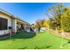 A well-manicured backyard with a putting green, patio with outdoor seating, and a view of the pool at 4675 S Bandit Rd, Gilbert, AZ 85297