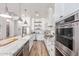 A modern white kitchen with stainless steel appliances, granite countertops, and ample cabinet space at 4675 S Bandit Rd, Gilbert, AZ 85297