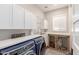 Bright laundry room featuring custom dog kennels, white cabinetry, countertop, and modern blue washer and dryer at 4675 S Bandit Rd, Gilbert, AZ 85297