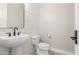 Modern powder room featuring a stylish pedestal sink, sleek fixtures, and unique patterned tile flooring at 4675 S Bandit Rd, Gilbert, AZ 85297