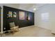 Bedroom showcasing dark accent wall, stylish decor, and a relaxing rocking chair on light wood floors at 4754 N 14Th St, Phoenix, AZ 85014