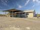 Exterior view of tan home with covered patio and desert landscaping at 48822 N Roughrider Rd, New River, AZ 85087