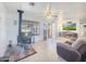 Bright living room featuring a wood burning stove, tile floors, and ceiling fan at 48822 N Roughrider Rd, New River, AZ 85087