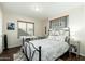 Cozy bedroom with a wrought iron bed, a desk, and a large window for natural light at 4887 E Armor St, Cave Creek, AZ 85331