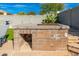 Built-in outdoor kitchen with BBQ grill, prep area, and stone accents, perfect for entertaining in the backyard at 4887 E Armor St, Cave Creek, AZ 85331