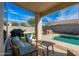 Inviting covered patio with comfortable seating, overlooking the sparkling pool and landscaped backyard at 4887 E Armor St, Cave Creek, AZ 85331