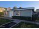 View of building featuring neutral siding, a well-maintained lawn, and mature landscaping at 510 N Alma School Rd # 103, Mesa, AZ 85201