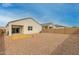 Gravel backyard offering a low-maintenance outdoor space with privacy fence and partial patio area at 5217 E Emery Rd, San Tan Valley, AZ 85143