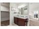 Bathroom vanity featuring double sinks, granite countertop, and decorative paintings on the wall at 5217 E Emery Rd, San Tan Valley, AZ 85143