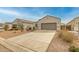 View of a single-story home with a neutral facade, complemented by a spacious driveway and desert landscaping at 5217 E Emery Rd, San Tan Valley, AZ 85143