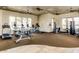 Well-equipped fitness center with cardio machines, weights, and ample natural light for residents at 5217 E Emery Rd, San Tan Valley, AZ 85143