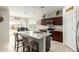 Modern kitchen featuring a granite island with seating, stainless steel appliances, and dark wood cabinetry at 5217 E Emery Rd, San Tan Valley, AZ 85143