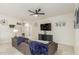 Comfortable living room featuring tile flooring, a sectional sofa, and a view into the hallway at 5217 E Emery Rd, San Tan Valley, AZ 85143