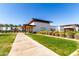 Modern clubhouse exterior with covered entry, desert landscaping, and sidewalk at 5460 S Dillon Cir, Mesa, AZ 85212