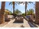 Outdoor firepit seating area with custom concrete benches and palm tree accents at 5460 S Dillon Cir, Mesa, AZ 85212