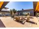 Picturesque outdoor patio with modern seating, umbrellas, and lush landscaping at 5460 S Dillon Cir, Mesa, AZ 85212