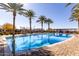 Bright swimming pool featuring palm trees, blue skies, and paver-stone decking at 5460 S Dillon Cir, Mesa, AZ 85212