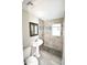 Bathroom featuring a tiled shower with black accents, pedestal sink, and tile floors at 6029 S 6Th Ave, Phoenix, AZ 85041