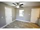 Cozy bedroom featuring light grey walls, stylish tile flooring, a ceiling fan, and two white doors at 6029 S 6Th Ave, Phoenix, AZ 85041