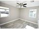 Sunny bedroom with stylish floors, light grey walls, ceiling fan, and dual windows providing natural light at 6029 S 6Th Ave, Phoenix, AZ 85041