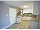 Bright kitchen with stainless steel vent hood, white cabinets, granite countertops, and decorative tile backsplash at 6029 S 6Th Ave, Phoenix, AZ 85041