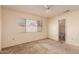 Bedroom with neutral walls, carpeted floors, a ceiling fan, and a large window; access to an en-suite bathroom at 6132 E Casper St, Mesa, AZ 85205