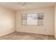 Bright bedroom featuring neutral walls, carpeted floors, a ceiling fan, and a large window for natural light at 6132 E Casper St, Mesa, AZ 85205