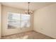 Bright dining room featuring neutral walls, carpeted floors, a large window for natural light, and a chandelier light fixture at 6132 E Casper St, Mesa, AZ 85205