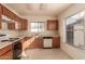 Efficient kitchen layout featuring classic appliances and wooden cabinets with light countertops, and a window over the sink at 6132 E Casper St, Mesa, AZ 85205