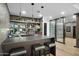 Stylish bar area with mirrored backsplash, open shelving, wine refrigerator, and temperature controlled wine storage at 7147 E Rancho Vista Dr # 6011, Scottsdale, AZ 85251