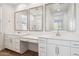 Bright bathroom featuring double sinks, white cabinetry, quartz countertops and decorative framed mirrors at 7165 S Bruins Rd, Gold Canyon, AZ 85118