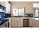 Bright kitchen with white cabinets, stainless steel appliances, and navy backsplash beneath a window at 723 W Canary Way, Chandler, AZ 85286