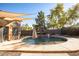 This backyard boasts a private pool with a fountain, patio area, and shade sails, ideal for outdoor relaxation and entertaining at 723 W Canary Way, Chandler, AZ 85286