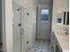 A well-lit bathroom with a glass-enclosed shower and stylish patterned floor tiles at 7654 W Tether Trl, Peoria, AZ 85383