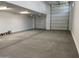 Spacious three car garage with white walls, concrete floors, and overhead lighting at 7654 W Tether Trl, Peoria, AZ 85383