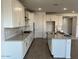 An open concept kitchen with white cabinetry, stainless steel appliances, and an island with bar seating at 7654 W Tether Trl, Peoria, AZ 85383