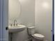 Stylish powder room featuring a pedestal sink, toilet, and modern fixtures at 7654 W Tether Trl, Peoria, AZ 85383