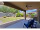 A covered patio leads to a lush backyard with well-maintained landscaping and charming, trimmed hedges at 9556 W Frank Ave, Peoria, AZ 85382