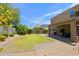 View of a landscaped backyard featuring a covered patio, lawn, trimmed hedges and a barbecue at 9556 W Frank Ave, Peoria, AZ 85382